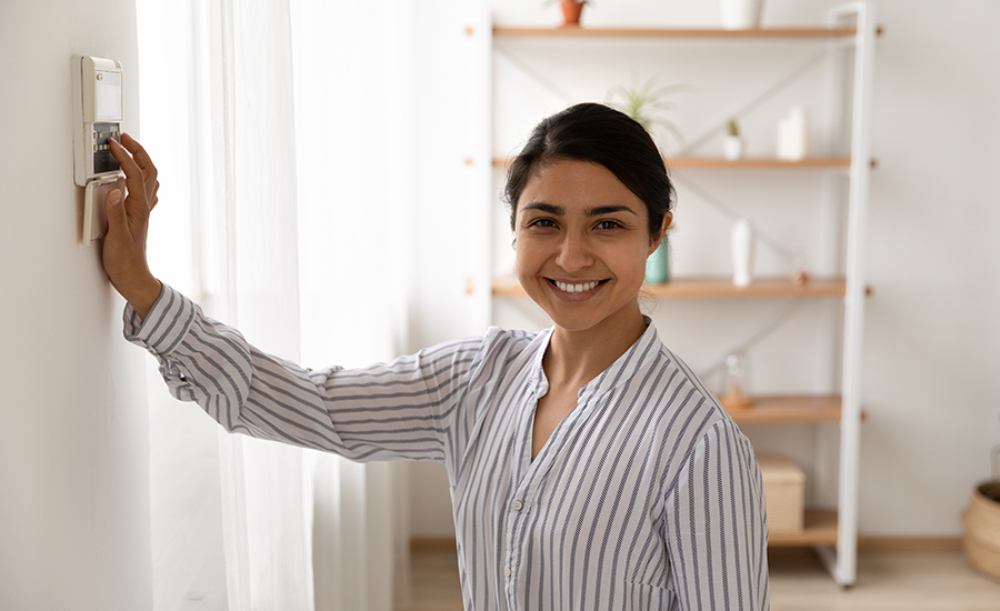 Personne souriante montrant les avantages de la domotique dans une habitation